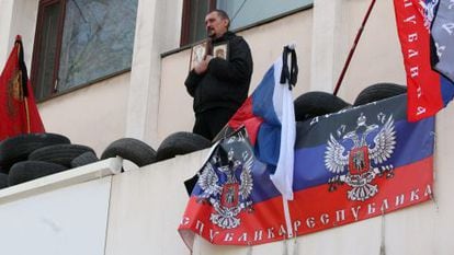Um ativista pró-Rússia reza na varanda do edifício do governo de Mariupol.