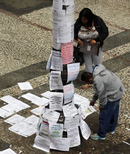 Transeuntes leem ofertas de trabalho em São Paulo.