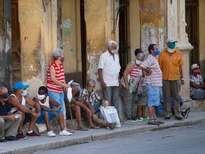 Várias pessoas esperam sua vez para comprar alimentos na sexta-feira em Havana.
