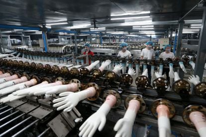 Linha de produção de luvas de vinil descartáveis em uma fábrica na China.