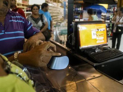 Clientes se identificam no sistema de compras biométrico em Maracaibo.