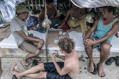 Um grupo de hondurenhos joga cartas enquanto espera a próxima partida, em Pijijiapan.