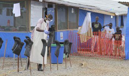 Meninos com ebola observam preparativos do funcionário encarregado de tratá-los, no condado de Bong (Libéria).