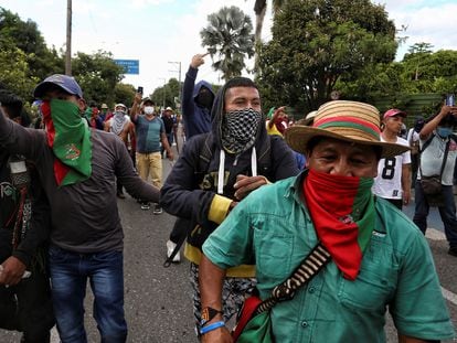 Indígenas caminham por uma rua durante uma manifestação em Cali, neste domingo. Em vídeo, o momento em que um grupo de civis armados se retira após abrir fogo contra a ‘minga’.