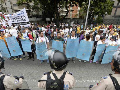 A policial vigia aos opositores antes da manifestação em Caracas.