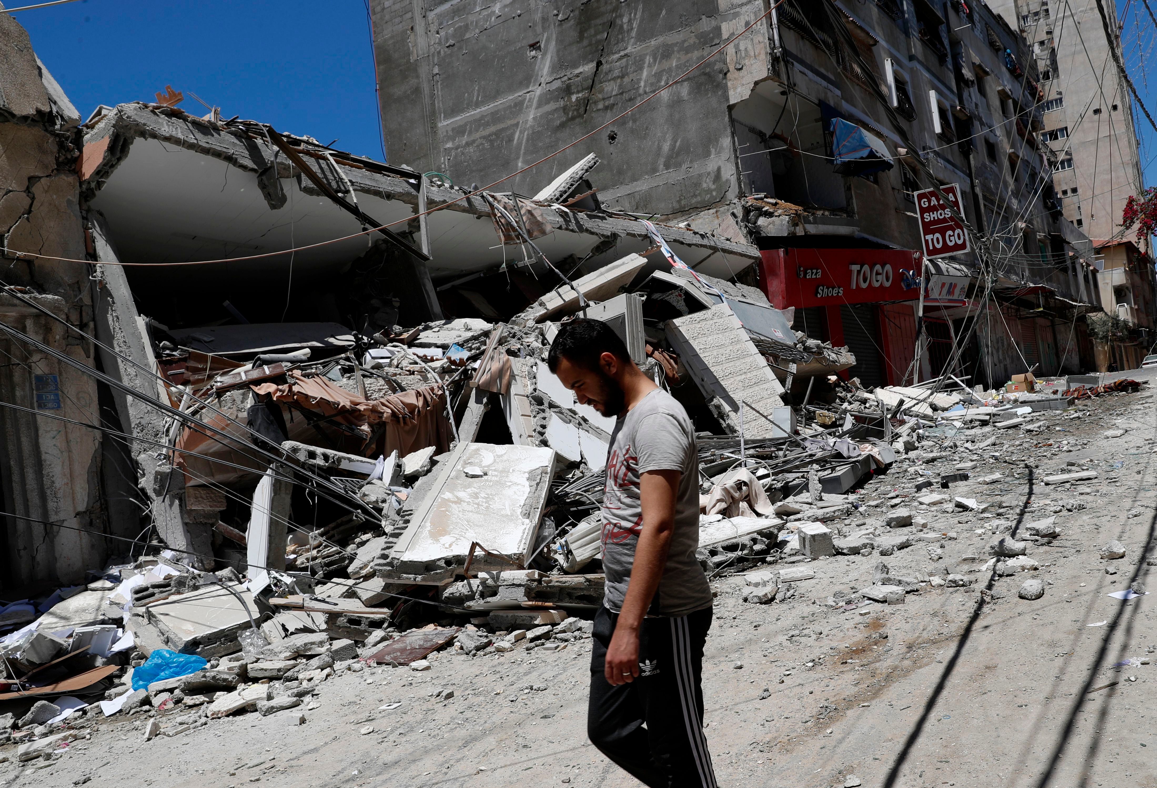 Um homem passa pelos destroços de um prédio destruído após ser atingido por ataques aéreos israelenses na Cidade de Gaza, nesta quinta-feira. 