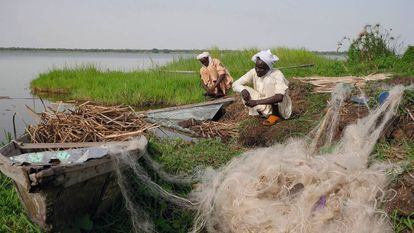 Dois pescadores trabalham em uma ilhota do lago Chad. Em meio século, as secas reduziram em mais de 90% esta grande massa de água.