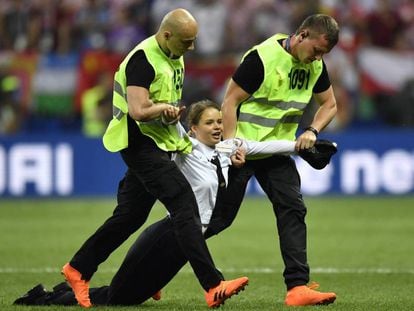 Uma mulher que irrompeu na final da Copa do Mundo é arrastada para fora do campo.
