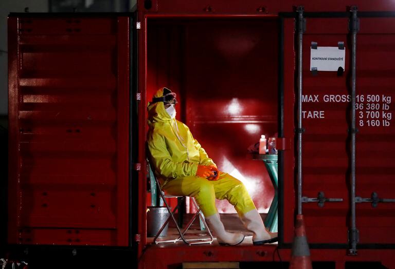 Medical staff member rests at a control station at the border crossing with Germany in Rozvadov, Czech Republic, Friday, March 13, 2020. The Czech Republic is renewing chedks on the borders with Austria and Germany at midnight Friday, and is barring entry to citizens from 15 "risk countries" due to the outbreak of the new coronavirus. (AP Photo/Petr David Josek)