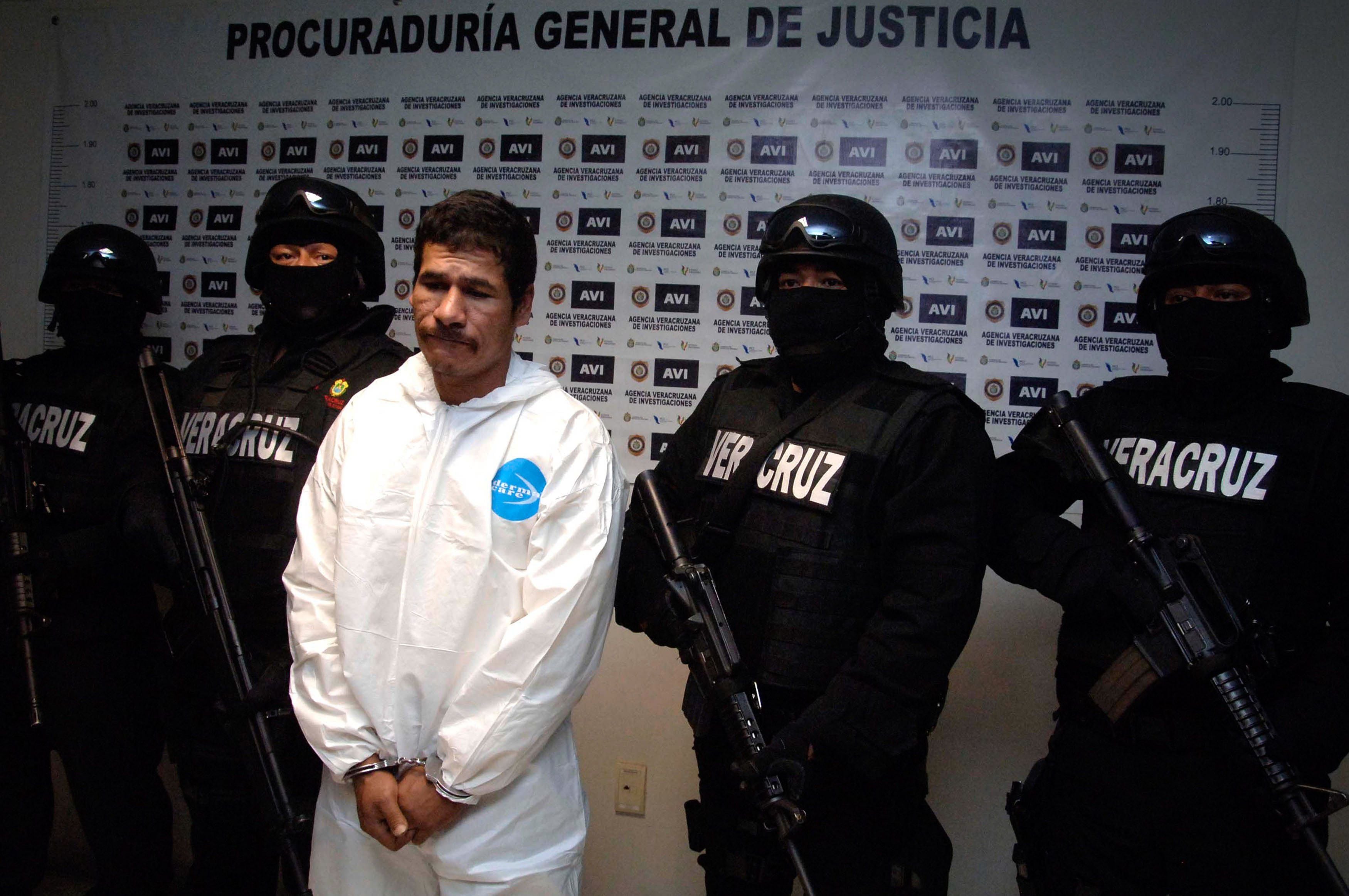 Pessoal da Procuradoria Geral de Justiça do Estado escolta José Antonio Hernández, conhecido como “El Silva”, quando foi apresentado como responsável pelo homicídio. 