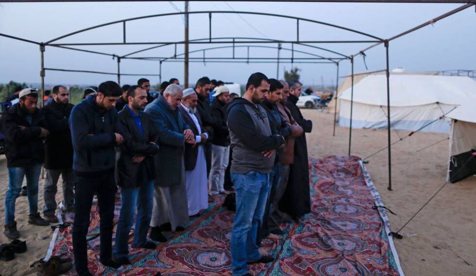 Grupo de muçulmanos palestinos no momento da oração, enquanto montam uma barraca na Faixa de Gaza em 29 de março de 2018
