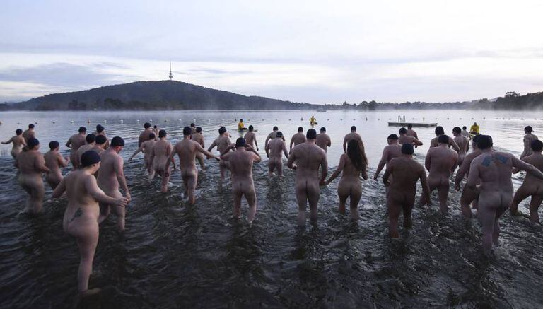 Dezenas de pessoas participam nuas nesta quinta-feira do banho de caridade pelo solstício de inverno no lago Burley Griffin, em Canberra (Austrália).