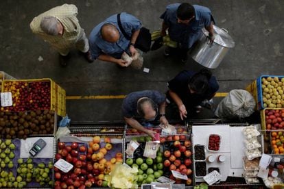 Clientes contam bolívares em um mercado de Caracas.