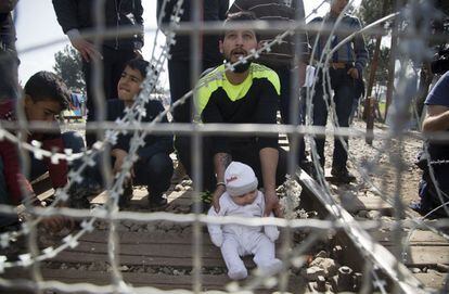 Homem e seu filho na fronteira entre a Grécia e a Macedônia, nesta terça-feira.