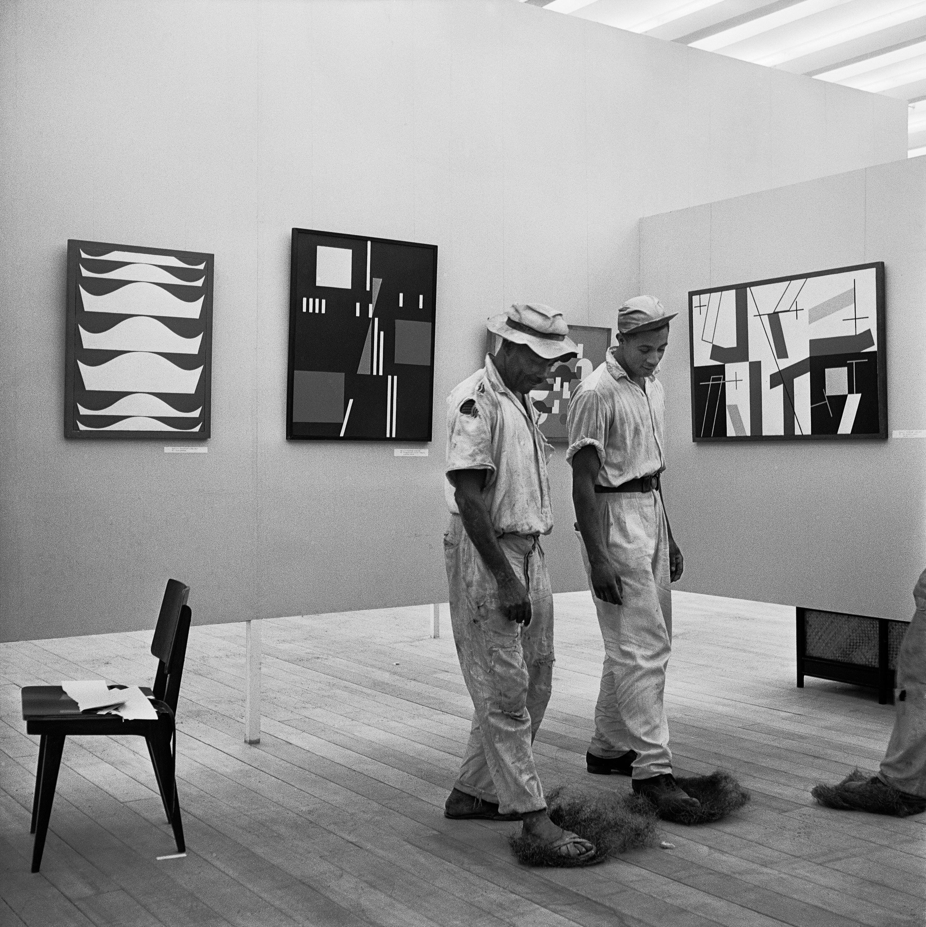 Montagem da I Bienal do Museu de Arte Moderna de São Paulo, esplanada do Trianon, avenida Paulista, 1951. Homens limpam a sala da delegação suíça, com pinturas de Sophie H. Taeuber-Arp.