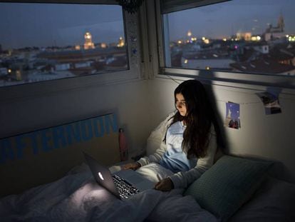 Adolescente assiste a série em seu quarto em Madri, durante a quarentena.