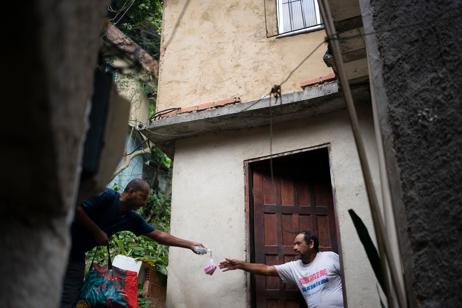 Voluntário entrega sabonete para um morador da favela da Rocinha, Rio de Janeiro, no dia 24 de março.