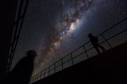 Duas pessoas observam a Via Láctea no monte Paranal (Chile).