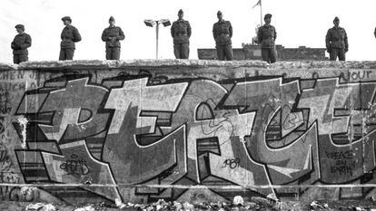 Pintada na cara ocidental do muro, vigiado por soldados orientais, em novembro de 1989.