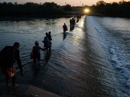 Um grupo de migrantes haitianos atravessa o rio Grande para obter alimentos e suprimentos perto do passo fronteiriço Del Río-Acuña, em Ciudad Acuña, Estado de Coahuila, México.