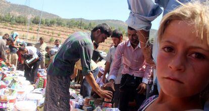 Refugiados yazidis recebem ajuda nas proximidades de Dohuk.