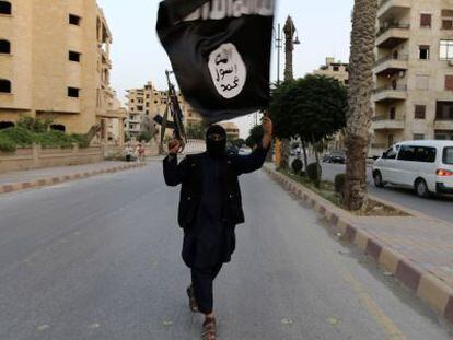 Em junho de 2014, um membro armado do Estado Islâmico acenando uma bandeira na cidade síria de Raqqa, reduto da organização jihadista.