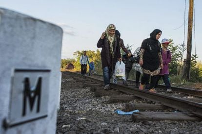 Refugiados caminham próximos à fronteira da Hungria.