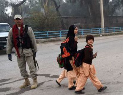 Alunos voltam às aulas vigiados pelas forças de segurança do Paquistão em Peshawar.