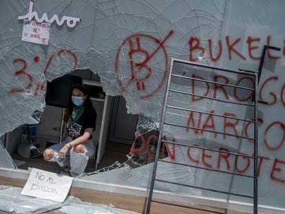 Uma manifestante dentro de um caixa de bitcoins destruído durante os protestos de quarta-feira.