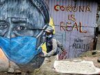 A man walks past a graffiti by Mathare Roots's youth group, which advocates against the spread of the coronavirus disease (COVID-19), at the Mathare Valley slum, in Nairobi, Kenya April 19, 2020. Picture taken April 19, 2020. REUTERS/Thomas Mukoya