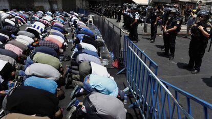 Fiéis palestinos oram diante da polícia israelense na porta de Damasco, em Jerusalém.