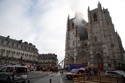 Imagem da catedral com a zona restrita e os bombeiros trabalhando para extinguir o fogo.
