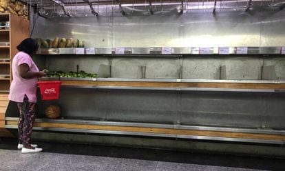 Mulher seleciona lim&otilde;es em um supermercado em Caracas.