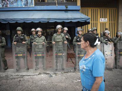 Agentes da Guarda Nacional Bolivariana protegem uma loja em Táchira.