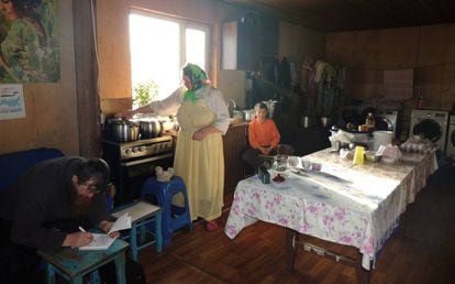 Ksenia e Ulian Murashov com um de seus filhos na cozinha da sua casa.
