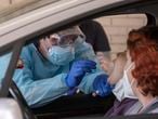 Un sanitario toma muestras a una mujer para una prueba PCR, en el hospital militar de Sevilla.