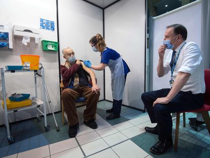 O diretor do Serviço Nacional de Saúde do Reino Unido, Simon Stevens, observa um paciente receber a vacina da Pfizer, nesta terça-feira, no Hospital Guy, em Londres.