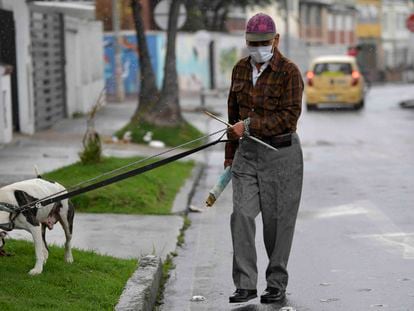Um homem usa uma máscara facial como medida preventiva contra a propagação do novo coronavírus, enquanto passeava com seu cachorro em Bogotá, em 16 de março de 2020.