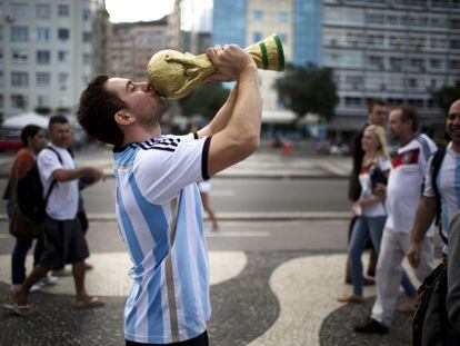 Um torcedor argentino beija uma réplica da Copa em Copacabana.