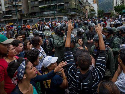 Manifestantes enfrentam membros da Guarda Nacional Bolivariana, em Caracas, em protesto contra a falta de alimentos.
