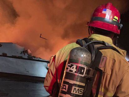 Um bombeiro trata de extinguir o incêndio declarado nesta segunda-feira em um barco em Califórnia.