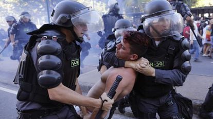 Policiais detêm manifestante em protesto no dia da final da Copa, no Rio.