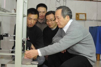 O físico Luo Jun (direita) e sua equipe, junto a um de seus aparelhos.