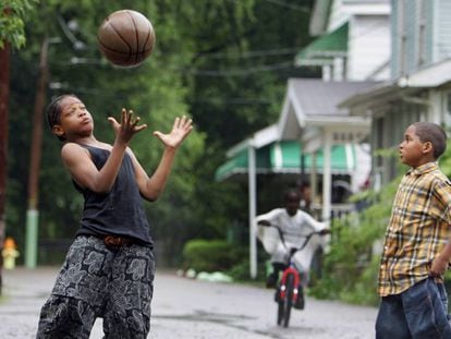 Dois garotos jogam basquete em uma rua de Akron.