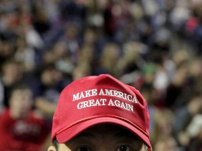 Um partidário de Trump com um boné com seu lema