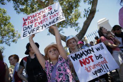 No cartaz da esquerda: "Direitos das mulheres. Todo o dia, a cada dia, em todos sítios!". Na da direita: As mulheres não serão trumpeadas!