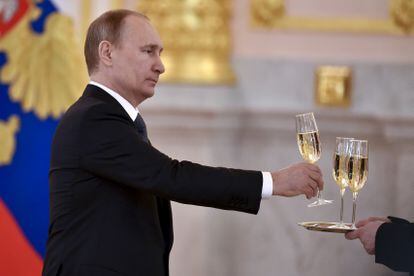 O presidente russo, Vladimir Putin, segura uma taça durante cerimônia no Kremlin, em 2016.