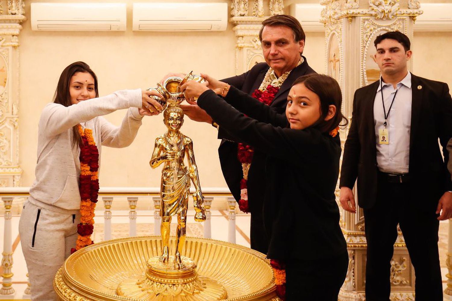 Bolsonaro com a filha Laura e a enteada Letícia durante visita ao Templo de Akshardham, em seu primeiro dia de visita oficial à Índia.