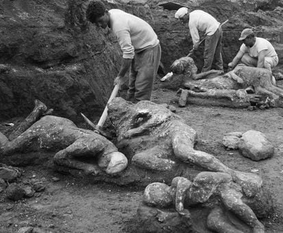 Arqueólogos extraem os corpos mumificados pela erupção de dois adultos e três crianças. / EL PAÍS