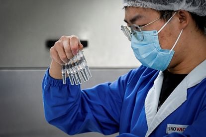 Funcionário examina um lote de vacinas na fábrica da Sinovac em Pequim.